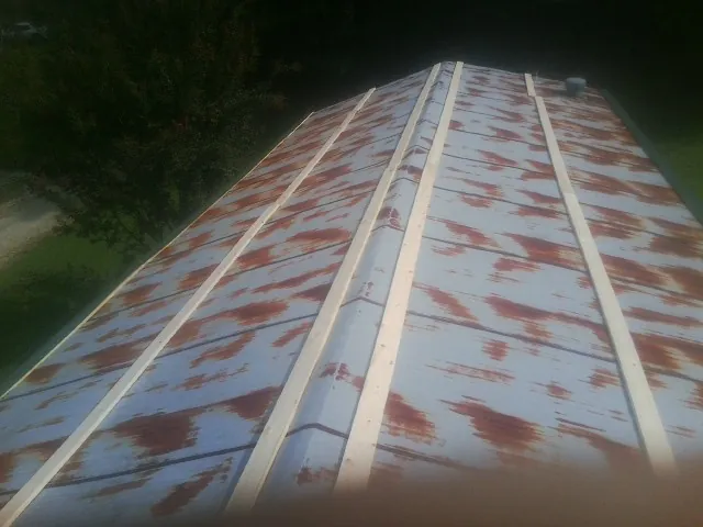 Rusted metal roof panels with new wood purlins before replacement — Storm Damage Roof Repair in Amber by Roofing Brothers
