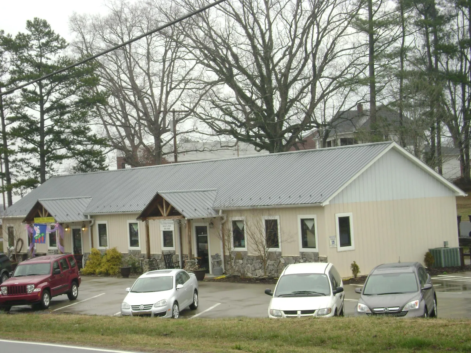 Gray metal roof with timber entry brackets on a small commercial building in Amber