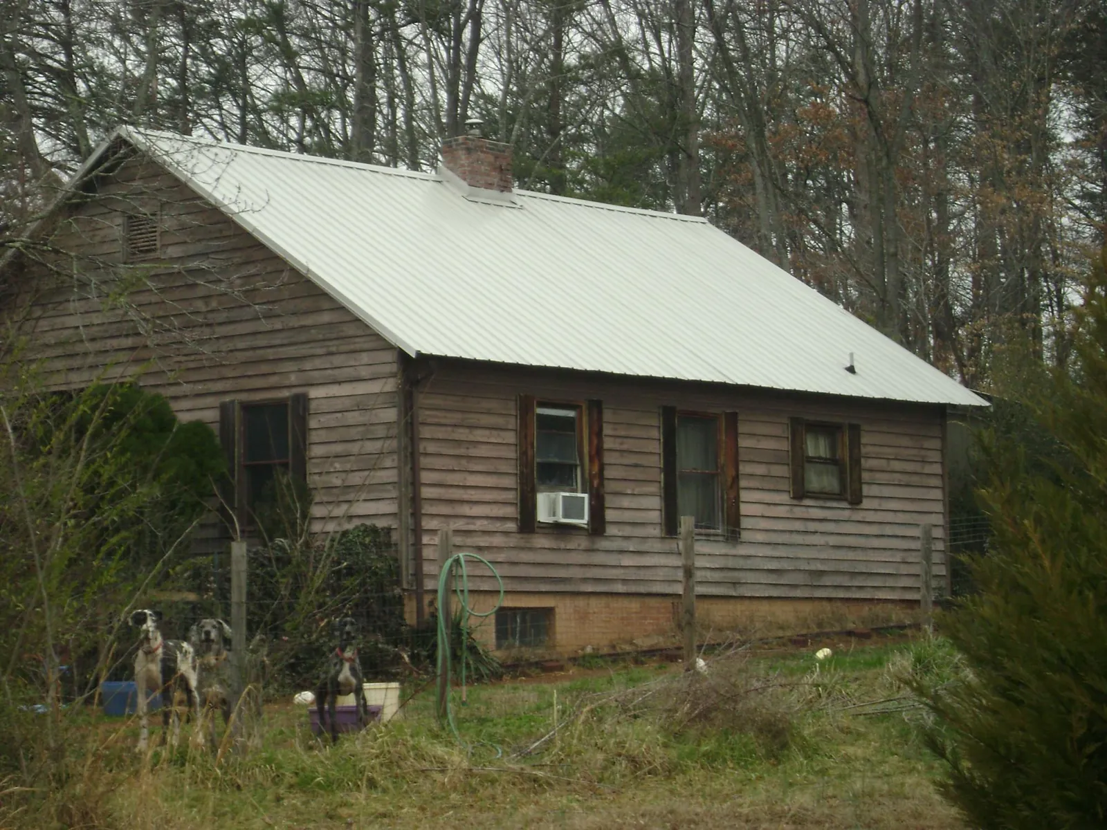 White metal roof on an old wood sided farmhouse, from a Metal Roof Installation job in Amber